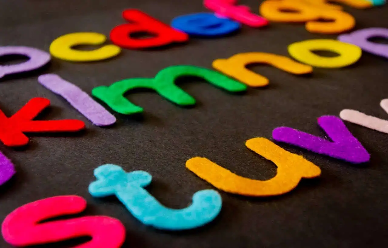 Colourful felt letters spelling "KINDNESS" on black background, promoting positive behaviour and social skills for children and young people.