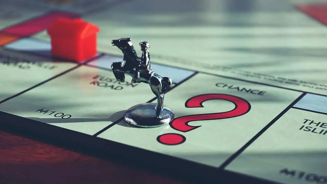 Miniature Monopoly game piece of a man on a horse on the 'Chance' space.