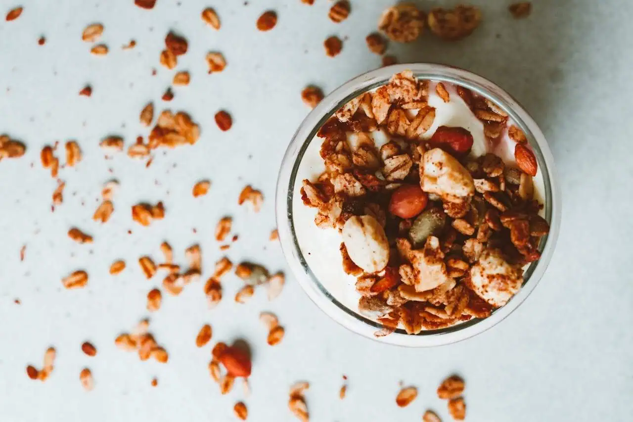 Crunchy homemade granola with nuts and seeds in a glass jar, healthy breakfast option, top view.