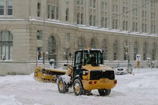 Snow removal machine clearing snow on city street in winter.