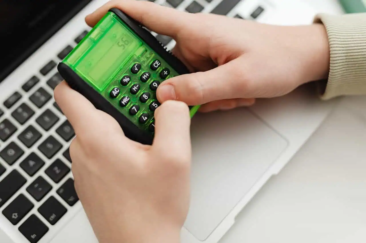 Compact green calculator on a laptop keyboard, representing financial planning or budgeting.