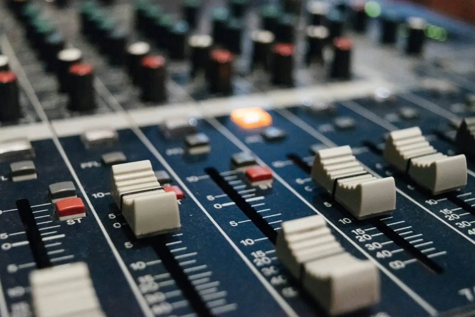 Sound mixing console with sliders and knobs for audio control, showcasing professional audio engineering equipment.