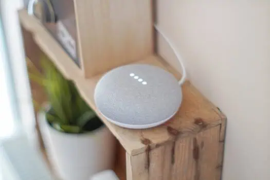 Smart home smart speaker on wooden shelf with potted plant, voice-controlled device for home automation and assistance, modern technology for everyday living.