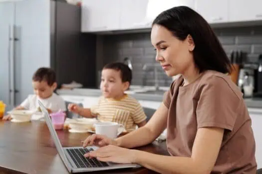 Laptop working mother with children during breakfast in kitchen, remote work, parenting, family life, home office, modern kitchen, multitasking, breakfast time, daily routine, remote working mom,.