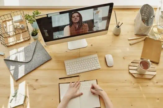 Bright home workspace with a desktop computer, keyboard, and notebook, showcasing a productive environment for remote work or online learning. Natural light creates a welcoming and organised setting.