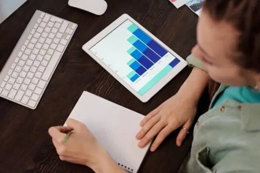 Flexible data analysis and organisation using a tablet with a colourful bar chart on a wooden desk. Suitable for remote work, business analytics, and productivity tools.