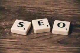Seo tiles on wooden surface, representing search engine optimisation for website ranking and digital marketing.