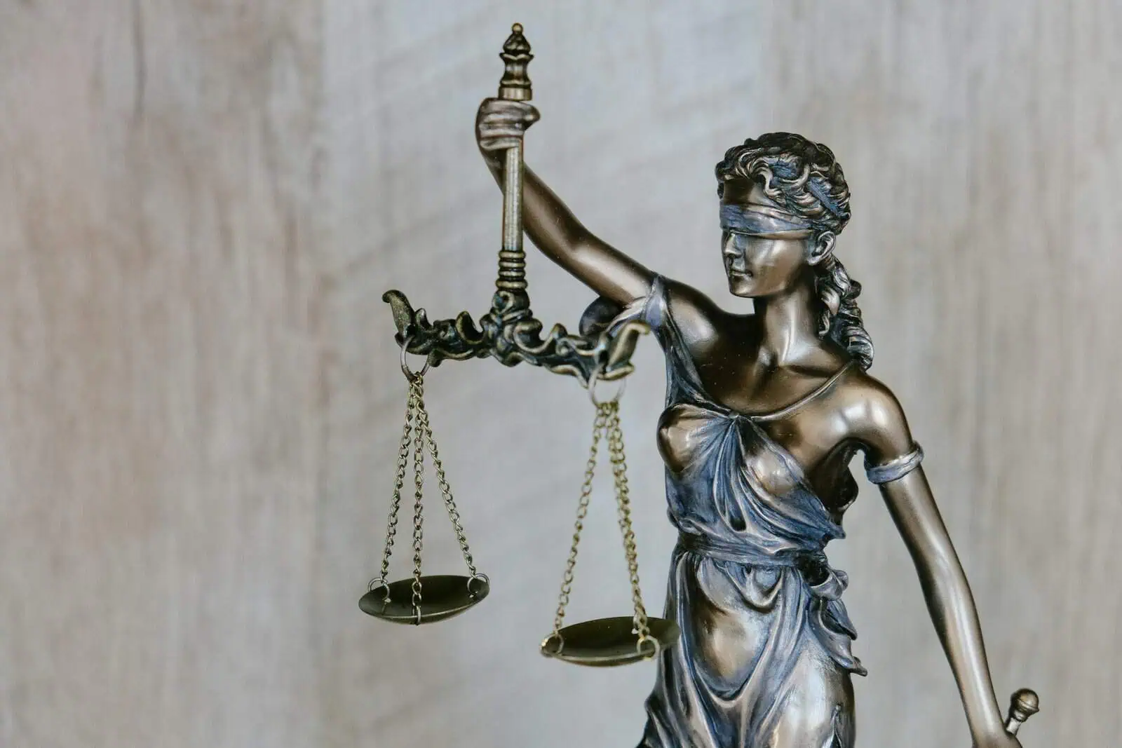 Antique bronze Lady Justice statue with blindfold holding balanced scales, symbolising fairness and impartiality in law. Perfect for legal, justice, or law firm SEO content.