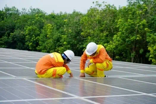 Solar panel installation, solar energy workers, renewable energy, sustainable power, green technology, eco-friendly energy solutions, outdoor solar panel maintenance, environmentally conscious professionals, solar power system setup, solar energy project.