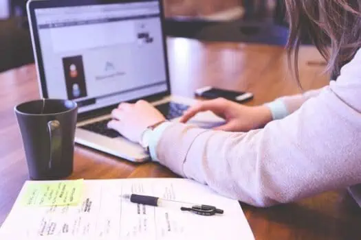 Laptop screen displaying social media or website content with a person working on a desk.
