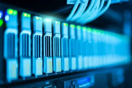 Cloud server racks with illuminated indicator lights in data centre, representing IT infrastructure and digital technology. High-tech servers and networking equipment for online security and data storage.