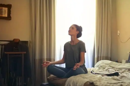 Calm woman practicing meditation in hotel room, mindfulness, relaxation, stress relief, yoga, wellness, mental health, tranquility, self-care, indoor relaxation.