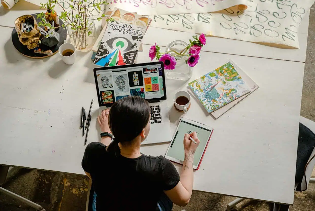 Creative workspace with digital design tools and art supplies in a modern office setting.