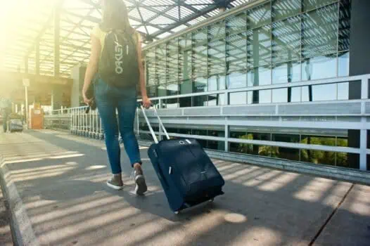 Luggage trolley at airport terminal, traveller pulling suitcase, modern travel, airport transportation, travel essentials, baggage handling, airport terminal architecture, journey, travel and tourism, airport travel essentials.
