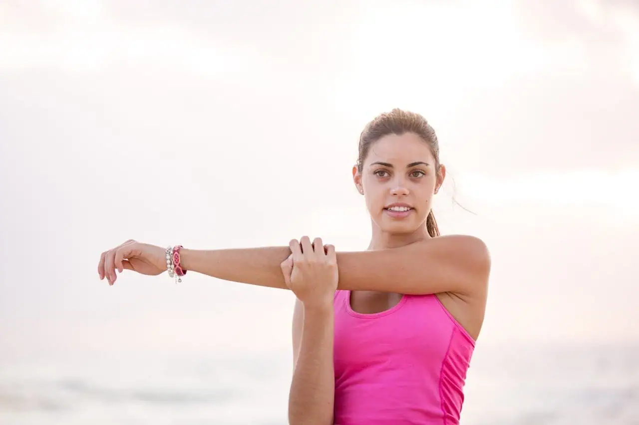 Stretching exercises for women at the beach during sunrise or sunset.