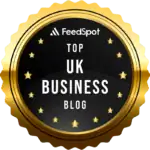 Medal-shaped badge with black and gold design highlighting "Top UK Business Blog" and "FeedSpot" icons for SEO recognition.