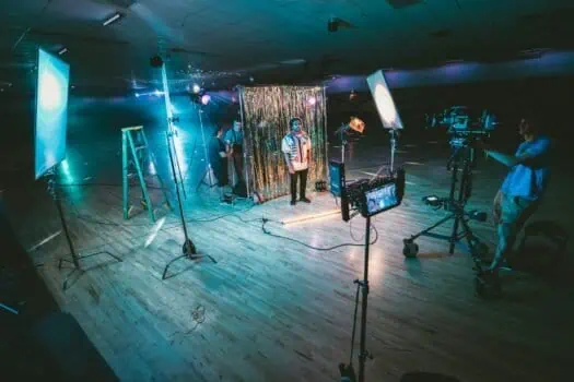 Creative filming session with professional lighting and camera equipment for a virtual performance, showcasing modern production techniques and studio setup.