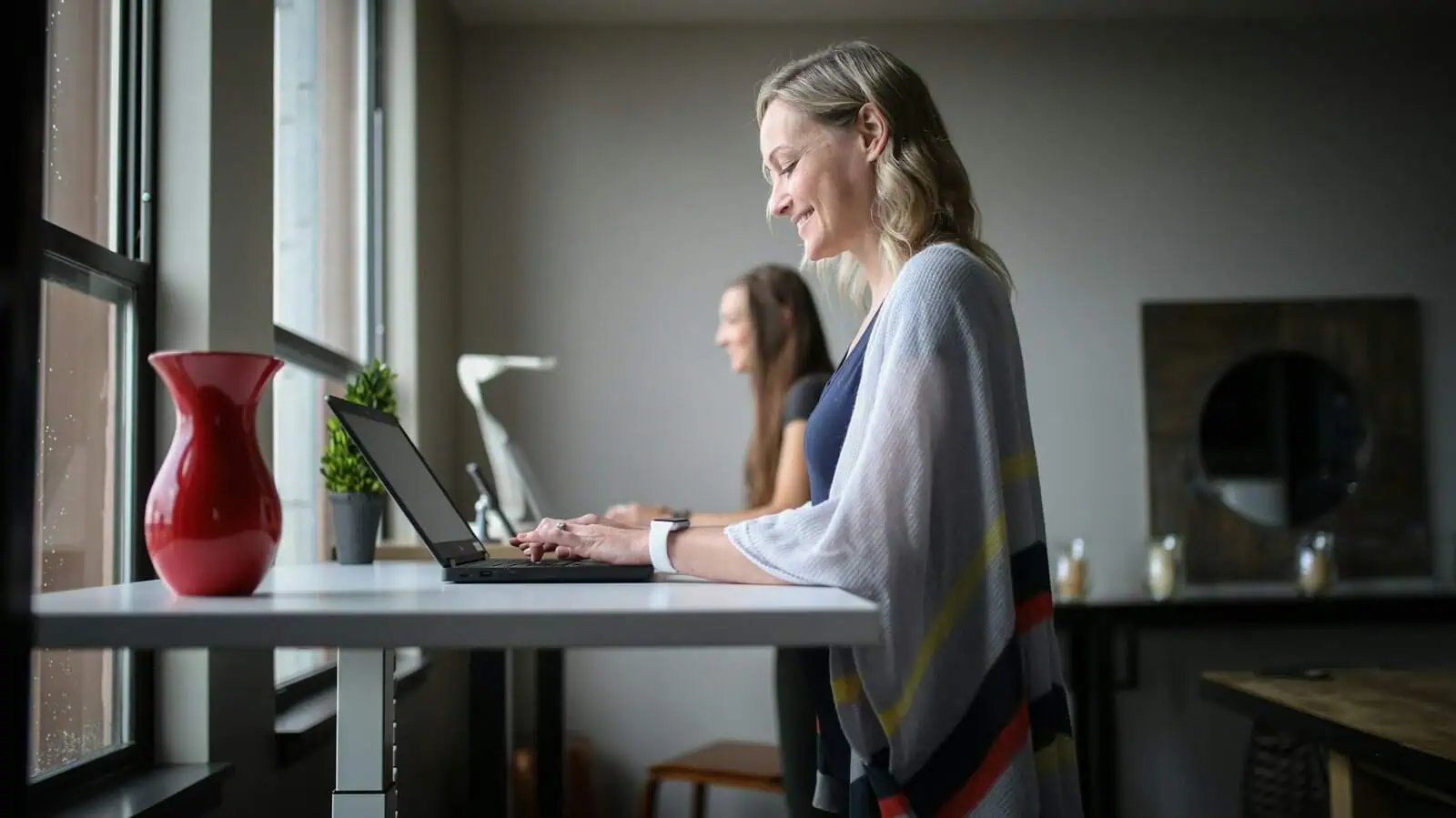 Secure working women using laptops in a modern office, promoting professional development and disability support services.