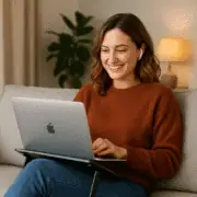 Accessible, friendly woman using a laptop on a sofa, engaging in online learning or remote work, representing digital skills development, online training, and accessible education.