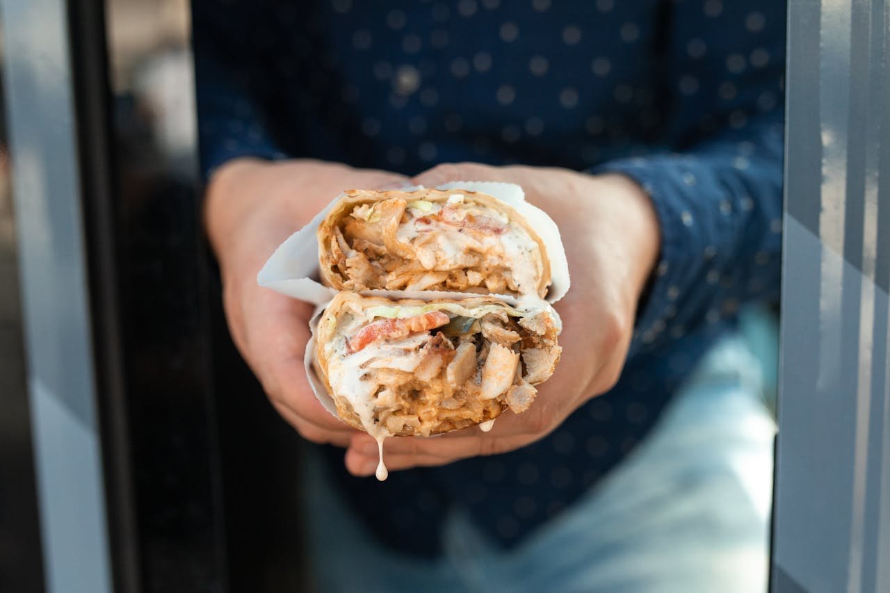 A close-up of a loaded shawarma wrap packed with spiced meat and fresh salad, like the popular Middle Eastern street-food dishes praised by locals in Birmingham.