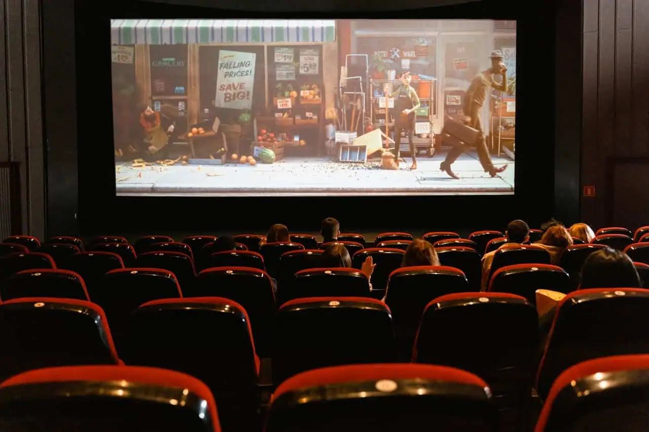 Audience watching a film scene depicting thrilling gambling moments on a large cinema screen.