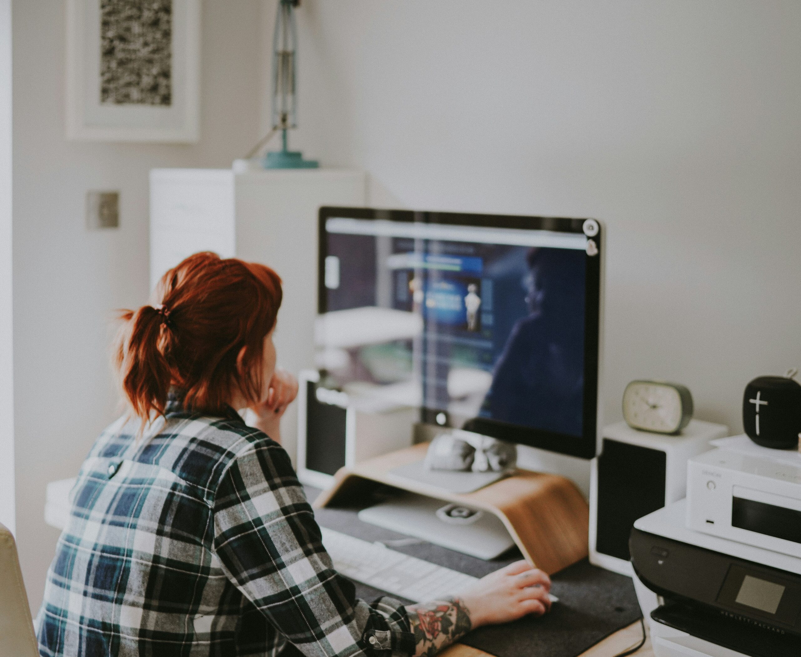Woman sitting at home in front of the computer screen and thinking about what she sees