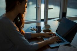 Woman sitting at home in front of the laptop screen