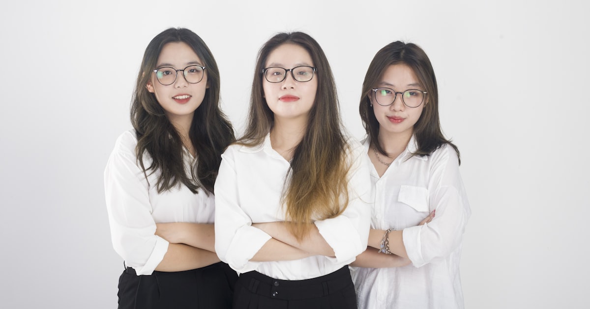 three women standing next to each other with their arms crossed