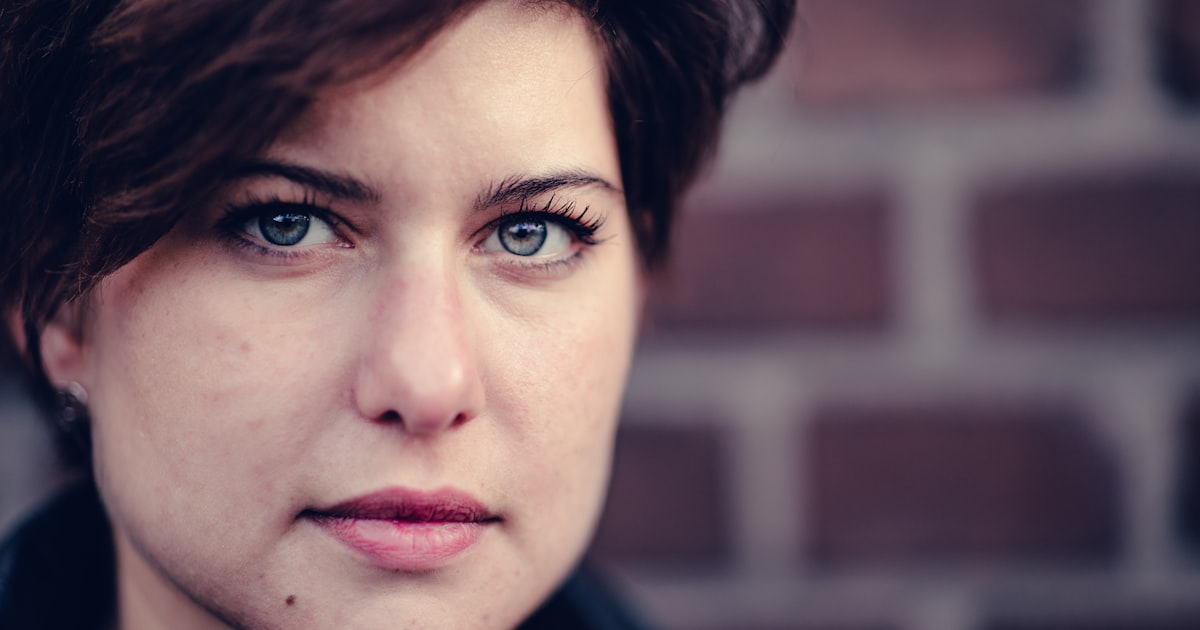 a close up of a person near a brick wall