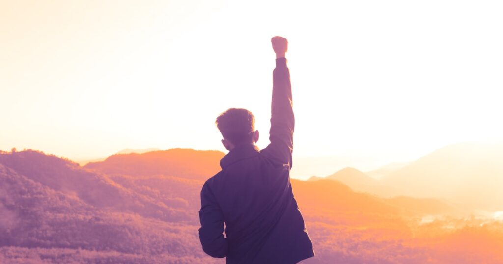 man raising his right arm during day