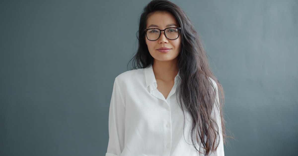 Woman with glasses wearing a white shirt.