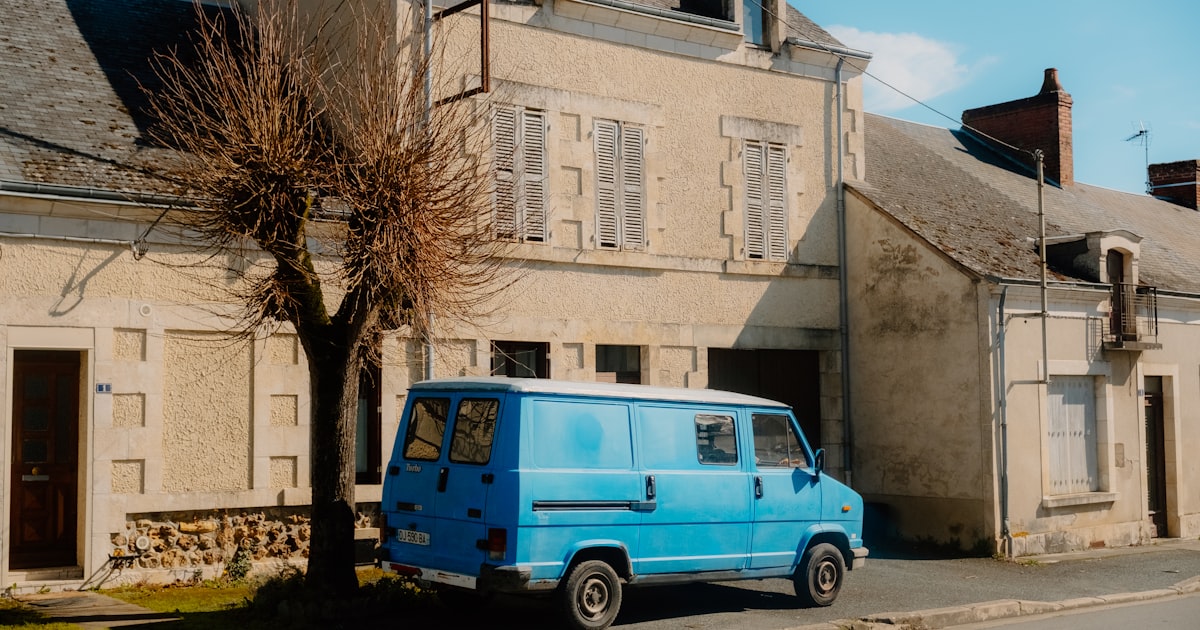 a blue van parked in front of a building