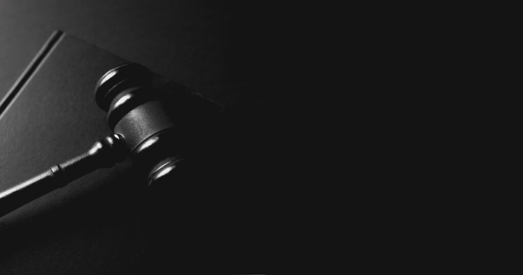 A gavel rests on a dark background.