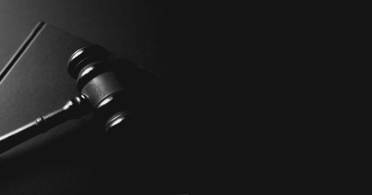 A gavel rests on a dark background.