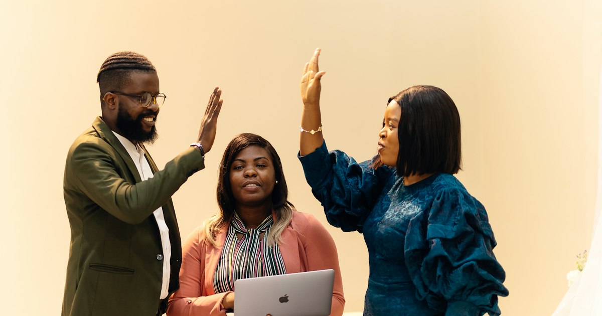 A team of three people, with a man and a lady facing opposite each other and another lady in the middle. Find more afro-centric images at www.ninthgrid.com