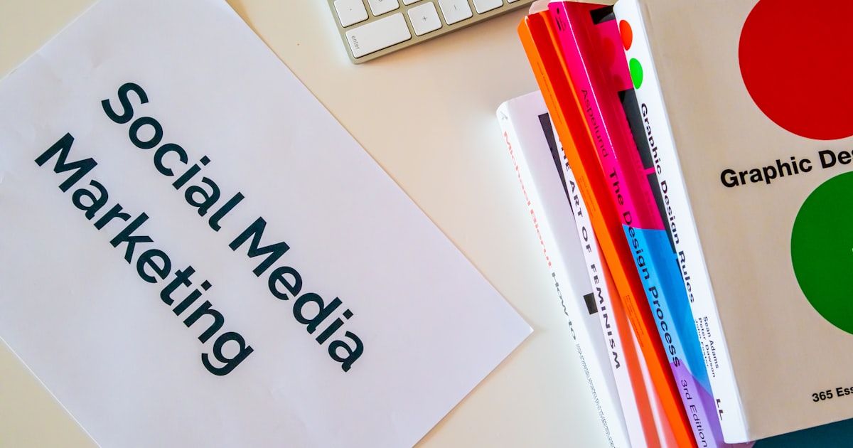 Home desk with design books and a paper with the words Social Media Marketing on it