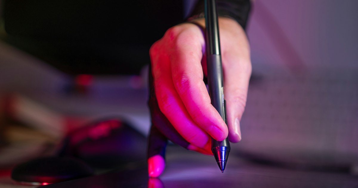 hand holding digital stylus on graphic tablet studio equipment creative tools neon light