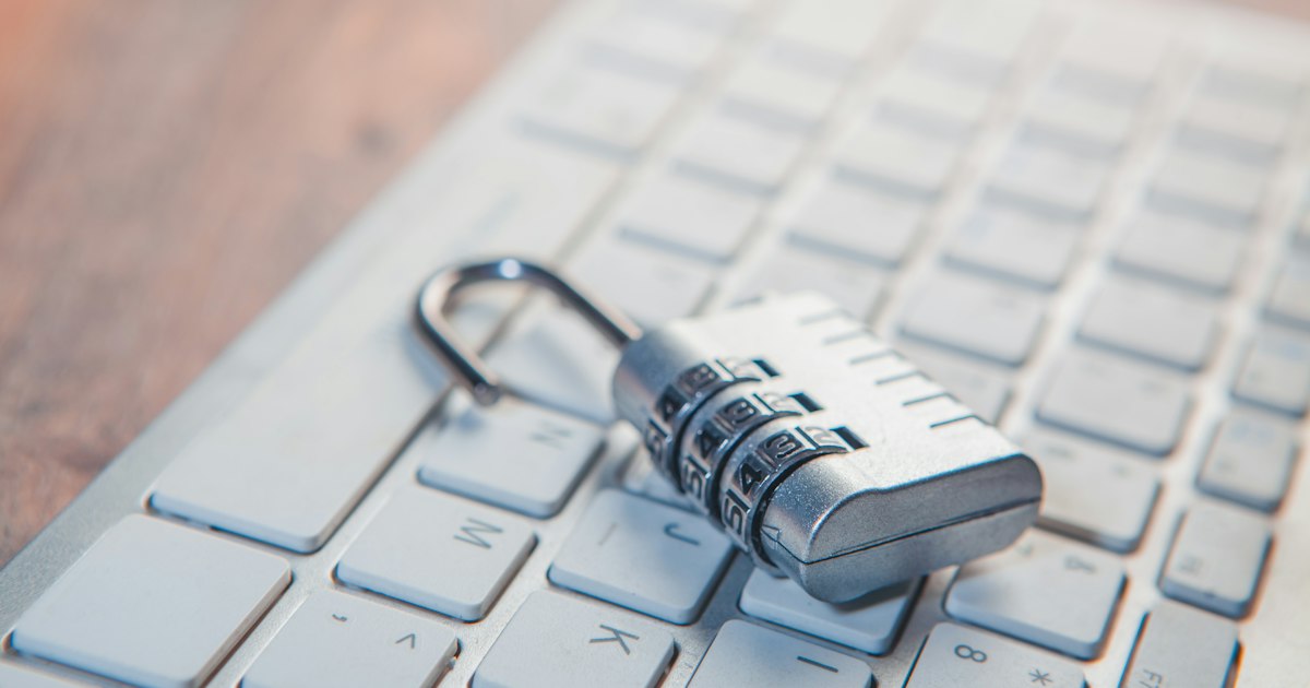 padlock with laptop computer on wooden background