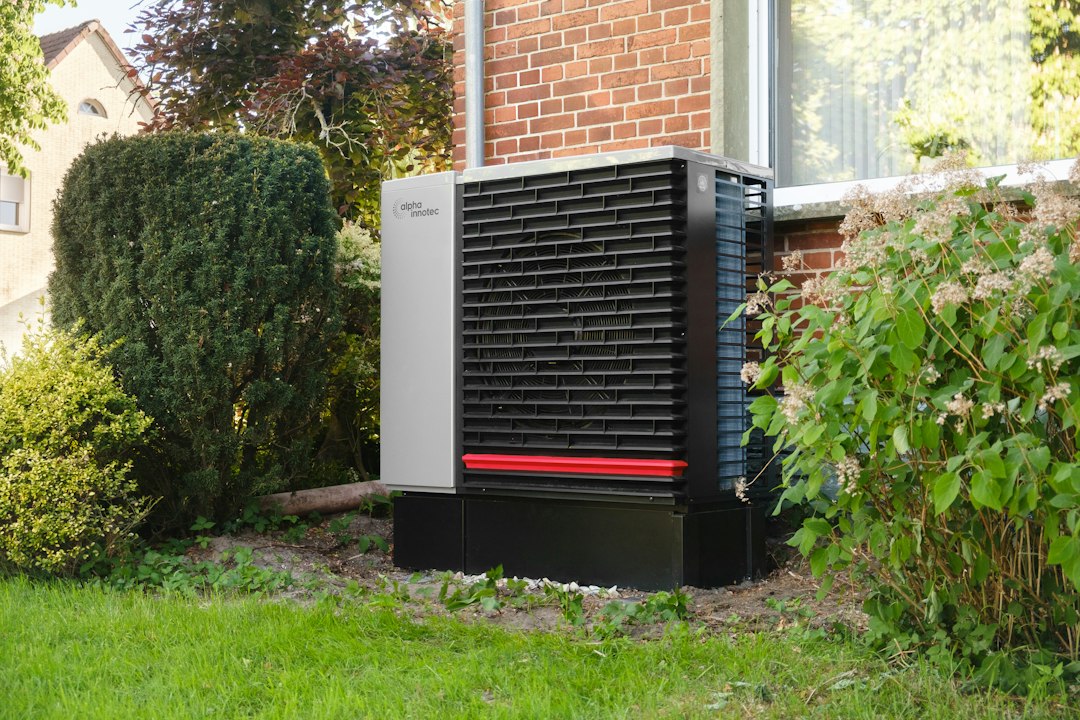 Outdoor heat pump unit next to a brick house